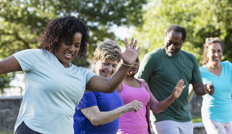 A group of 5 people dancing while watching the instructor