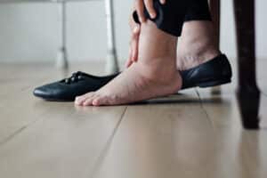 Elderly woman swollen legs putting on shoes